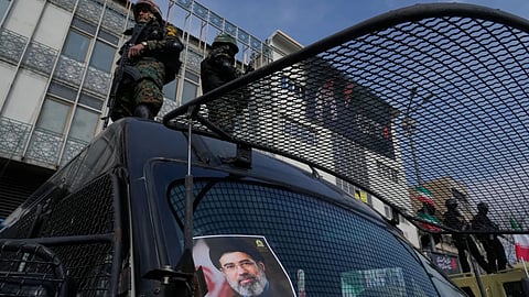 A poster of Ayatollah Mojtaba Khamenei, the successor to his late father Ayatollah Ali Khamenei as supreme leader is placed on an anti-riot police car as policemen stand on top of the car, during a rally to support him in Tehran, Iran