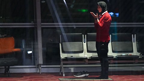 A member of Iran's women's soccer team prays at the Kuala Lumpur International Airport in Sepang, Malaysia.