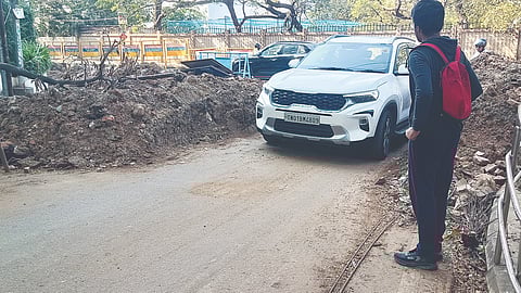 A pedestrian waits for the car to pass through the narrow stretch