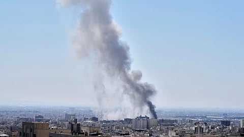 A plume of smoke rises after a strike in Tehran, Iran.