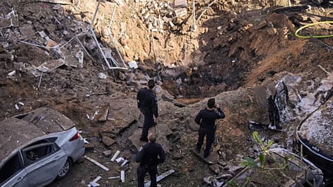 Israeli security forces and rescue teams inspect the site of an Iranian missile strike in Tel Aviv, Israel