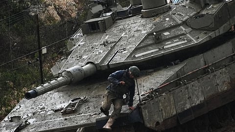 An Israeli soldier jumps from a tank in northern Israel near the border with Lebanon