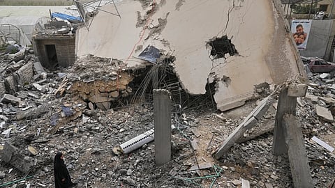 A woman checks a destroyed house that was hit in an Israeli airstrike in Saksakiyeh village, south Lebanon