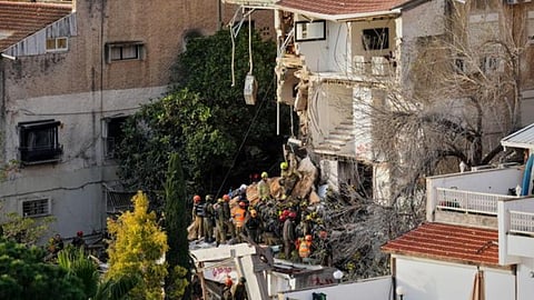Israeli rescue teams search for missing people amid the rubble of a residential building a day after it was struck by an Iranian missile in Haifa, Israel