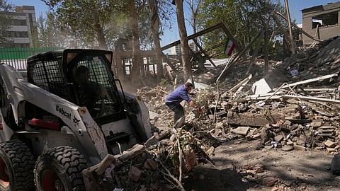Workers remove debris at Tehran's Sharif University of Technology complex that Iranian authorities say was hit early Monday by a U.S.-Israeli strike, in Tehran