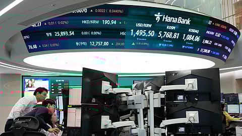 Currency traders watch monitors near a screen showing the Korea Composite Stock Price Index (KOSPI), top center, and the foreign exchange rate between U.S. dollar and South Korean won, top center left, at the foreign exchange dealing room of the Hana Bank headquarters in Seoul, South Korea