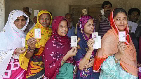 Women wait in a queue before voting in the first phase of the West Bengal Assembly elections, at a polling station in Panskura, Purba Medinipur