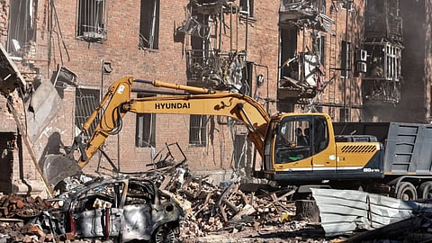 An excavator clears the rubble of a residential building destroyed by a Russian strike on Dnipro, Ukraine