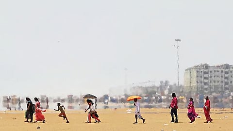 People walking on a beach under the hot sun