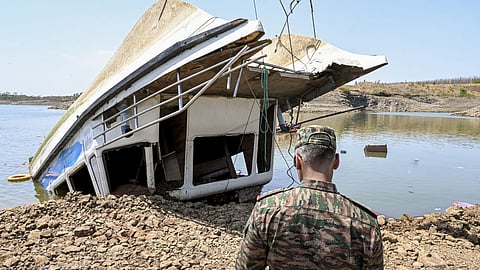A security official present at the site as the NDRF and other rescue personnel conduct an operation to recover the cruise boat, carrying 29 passengers and two crew members, that overturned in Bargi Dam due to a sudden storm, in Jabalpur district, Madhya Pradesh, Friday, May 1, 2026. The death toll rose to nine and 28 others were rescued after the incident.