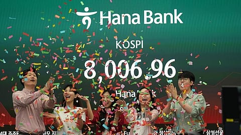 Employees of Hana Bank celebrate in a photo-op to mark the Korea Composite Stock Price Index (KOSPI) of over 8,000 points at a dealing room of Hana Bank in Seoul, South Korea, Friday, May 15, 2026.