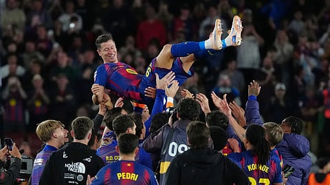 Barcelona's Robert Lewandowski is thrown into the air by his teammates after his last game for the club at the end of the Spanish La Liga soccer match between FC Barcelona and Real Betis in Barcelona, Spain