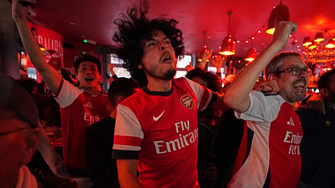 Arsenal supporters celebrate as they watch the Premier League match between Bournemouth and Manchester City in a pub near the Arsenal stadium in London, Tuesday, May 19, 2026