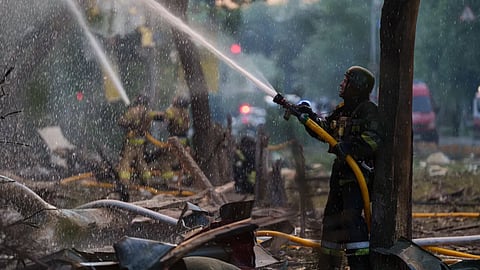 Rescue workers try to put out a fire at a residential building after a Russian strike on Kyiv, Ukraine, on Sunday, May 24, 2026.