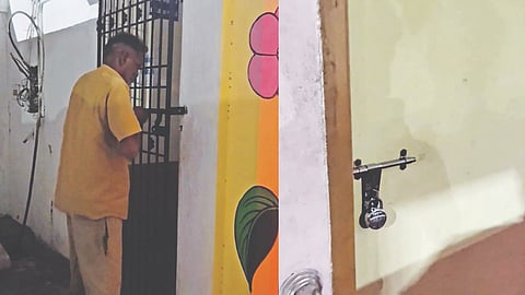 A contract worker on night duty at the terminus locks toilet gate at Anna Bus Stand in Tambaram Sanatorium