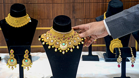 A salesman arranges a necklace at a jewellery shop.