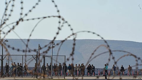 Migrants rescued south of Crete walk after their arrival at the the port of Lavrio, Greece