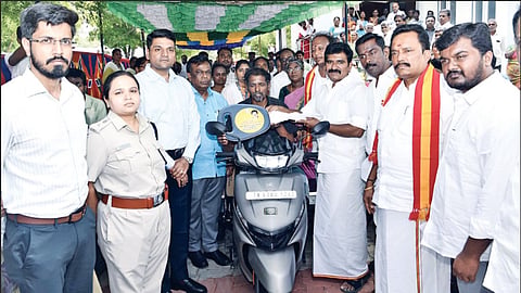 Minister Nirmalkumar handing over welfare aid to a beneficiary in Theni