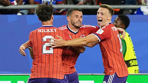 Scotland's John McGinn (7) celebrates with teammate's Aaron Hickey (2) and Lewis Ferguson (19) after scoring his teams first goal during the World Cup