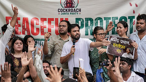 Cockroach Janta Party (CJP) founder Abhijeet Dipke, centre in white, addresses the gathering as its spokesperson Ashutosh Ranka, back centre, looks on during a protest demanding the resignation of Union Education Minister Dharmendra Pradhan over alleged examination-related lapses, at the Jantar Mantar
