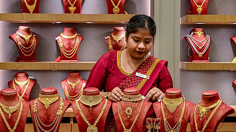 A vendor displays gold jewellery for sale at a store