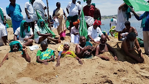 Protesting farmers bury themselves in the dry Cauvery river bed in Tiruchy on Tuesday