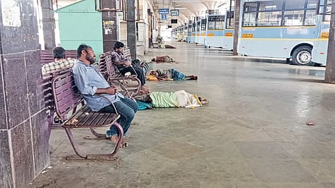 Men consume alcohol and sleep on the chairs placed in the bus parking bays at the terminus
