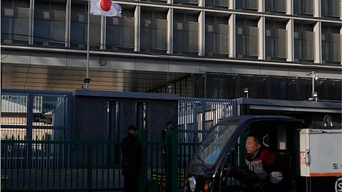 A delivery man drives past the Japanese Embassy in Beijing
