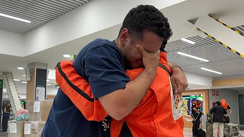 German Bello, right, a volunteer with the Mexican search-and-rescue brigade Los Topos Azteca, embraces a Venezuelan man who approached the team to thank them as they departed for Venezuela from Mexico City's airport