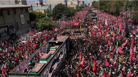 The truck carrying the coffins of the slain Iranian Supreme Leader Ayatollah Ali Khamenei and members of his family makes its way through mourners during the funeral procession toward Azadi Tower in Tehran, Iran.