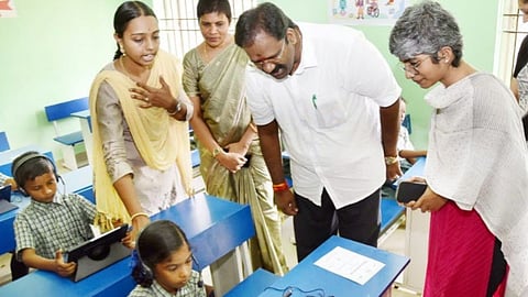 Minister R V Ranjithkumar observing the students undergoing tablet-based language training.