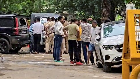 Police officer carries arms and ammunition recovered from the site of an encounter between Gurugram Police Crime Branch teams and suspected criminals in the Sushant Lok Phase-2 area