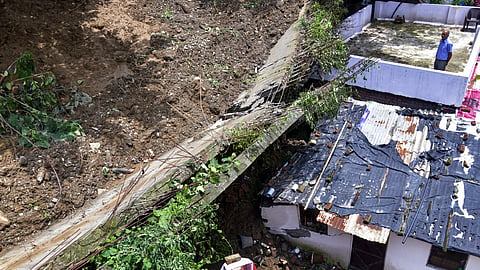 Damaged remains of a portion of a wall after it collapsed after heavy rainfall and gusty winds, in Khala Basti area, Dehradun, Sunday, July 12, 2026