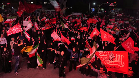 Pro-government demonstrators wave Iranian and religious flags in a gathering commemorating the late Iranian Supreme Leader Ayatollah Ali Khamenei at a square in Tehran.