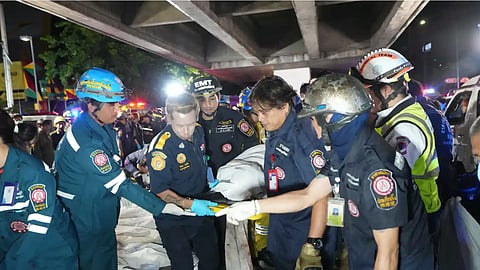 Rescuers carry the body of a victim of a fire in Bangkok, Thailand