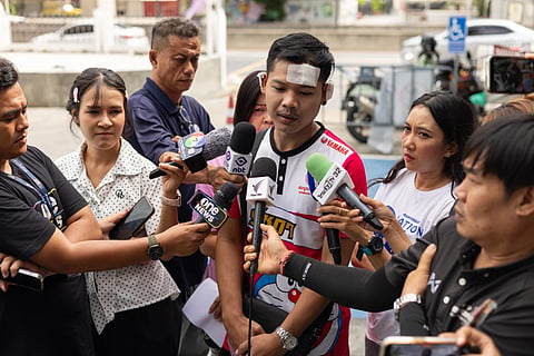 Natthaphong Lakhorn, a 26-year-old survivor of the Rong Beer Na Ladprao bar fire, speaks to journalists outside the Phahonyothin Police Station in Bangkok, Thailand, Wednesday, July 15, 2026.