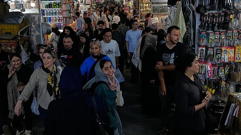 A woman flashes a victory sign while walking at Tehran’s traditional main bazaar, Iran.