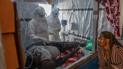 Health workers tend to an Ebola patient at the Rwampara Treatment Center in Ituri, Congo.