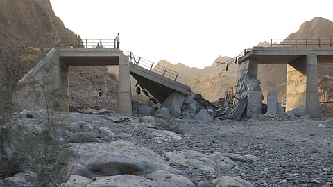People stand on a bridge destroyed after a strike in Hormozgan province, southern Iran.