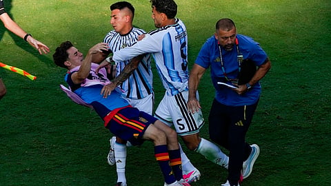 Spain’s Gavi, left, falls as he scuffles with Argentina’s Leandro Paredes (5) and Thiago Almada during the World Cup final soccer match between Spain and Argentina in East Rutherford