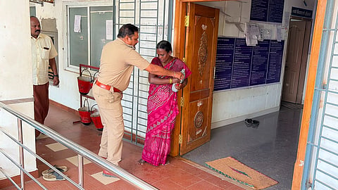 Police snatches away kerosene can from Nithya at Sub-Registrar's office in Pattukkottai on Wednesday