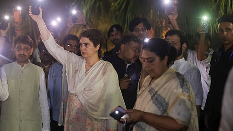 Congress leader Priyanka Gandhi Vadra and opposition MPs switch on torches on their mobile phones at the Gandhi Smriti, in New Delhi