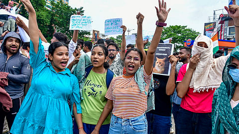 People raise slogans during a protest demanding the resignation of Union Education Minister Dharmendra Pradhan over alleged irregularities in the NEET examination