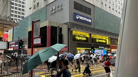 Passersby walk in Hong Kong's Mong Kok district under heavy rain and wind ahead of Typhoon Noul on Saturday, July 25, 2026
