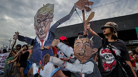 Protesters carry an effigy of U.S. President Donald Trump and Philippine President Ferdinand Marcos Jr. during a protest march in Quezon City, Philippines, ahead of the State of the Nation Address by President Marcos Jr