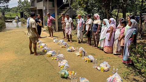 Volunteers distribute relief materials to flood-affected people, in Sivasagar district, Assam