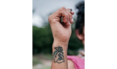 A woman showing the tattoo of one of her traffickers