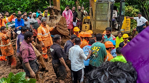 Rescue personnel and people during a rescue operation following a landslide due to rain triggered floods, in Kottayam, Kerala, Saturday
