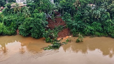 Severe soil erosion causes a riverbank collapse along the swollen Chaliyar River, threatening houses at Mundengara in Malappuram district