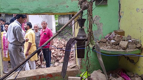 People gather after a portion of a dilapidated house collapsed